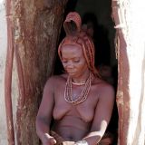 Diese Himba-Frau demonstriert wie die rote Farbe weiterverarbeitet wird.
