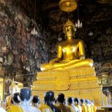 Steinerne Mönchsfiguren beten vor einer Buddha-Figur in einem der Tempel von "Wat Suthat Thepwararam".
